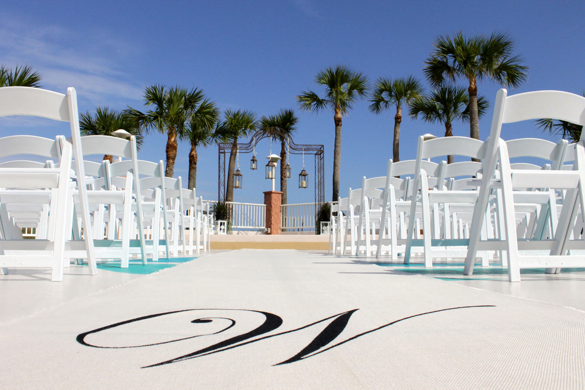 rows of outdoor wedding chairs in front of beach altar